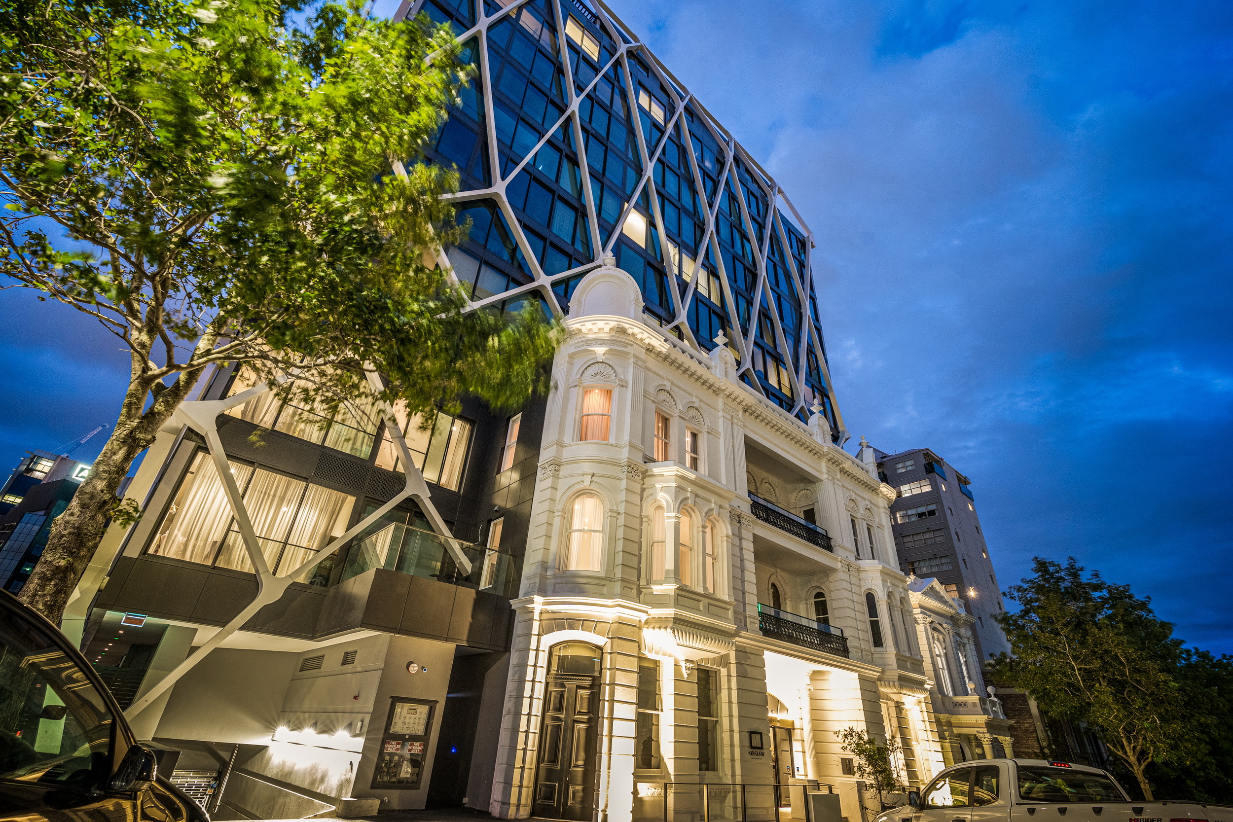 The International at dusk, the restored Grand Hotel façade beneath the white exoskeleton tower